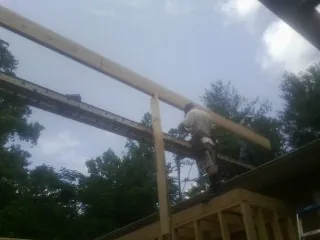 Carpenter setting a ridge beam over a new addition frame — Ice Dam Removal by Roofing Brothers in Weippe